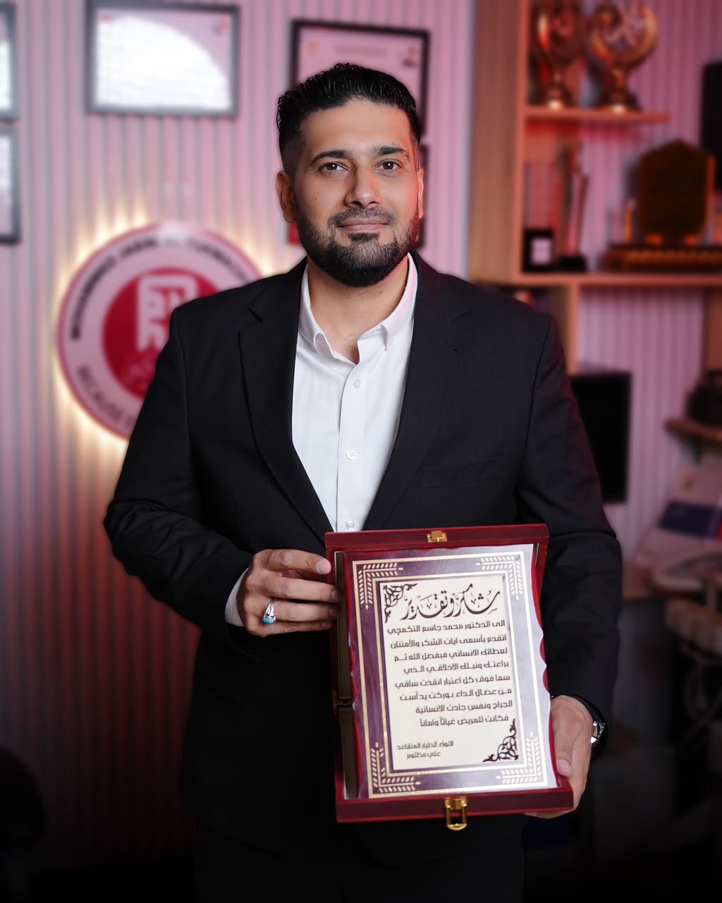 الدكتور محمد جاسم التكمجي يحمل درع شكر وتقدير من أحد مرضاه